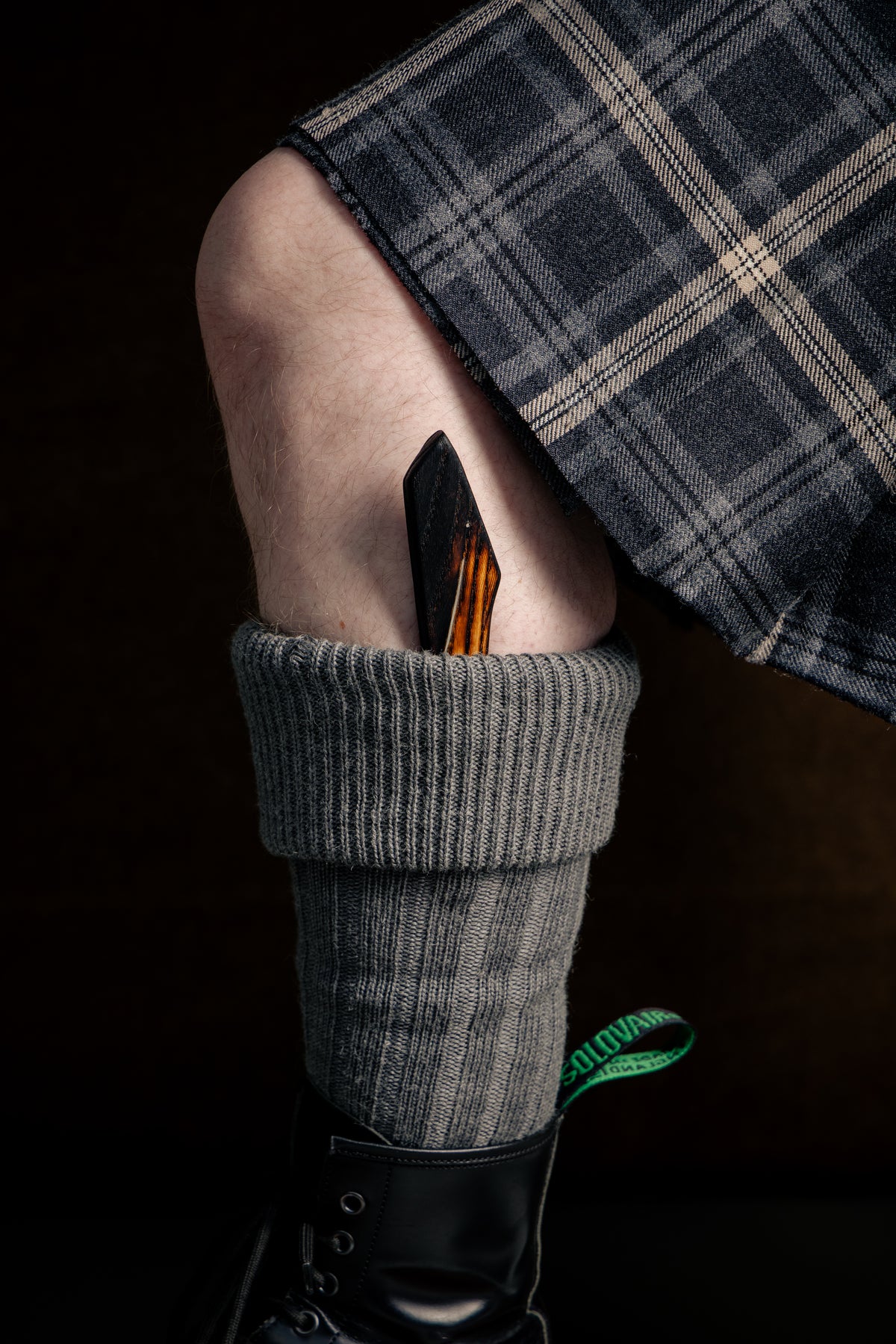 Ash Sgian Dubh tucked into grey kilt socks, worn with black Doc Marten boots and a grey kilt.