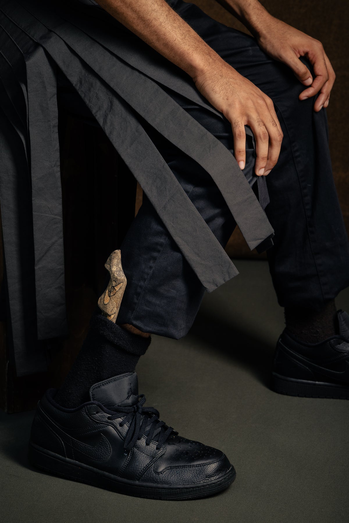 The Spalted Beech Sgian Dubh worn tucked into the sock, paired with black trainers, jeans and a grey contemporary kilt skirt.