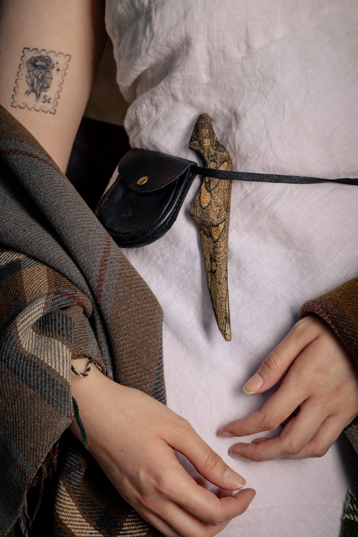 A close up of the Spalted Beech Sgian Dubh worn tucked into the belt against a white dress.